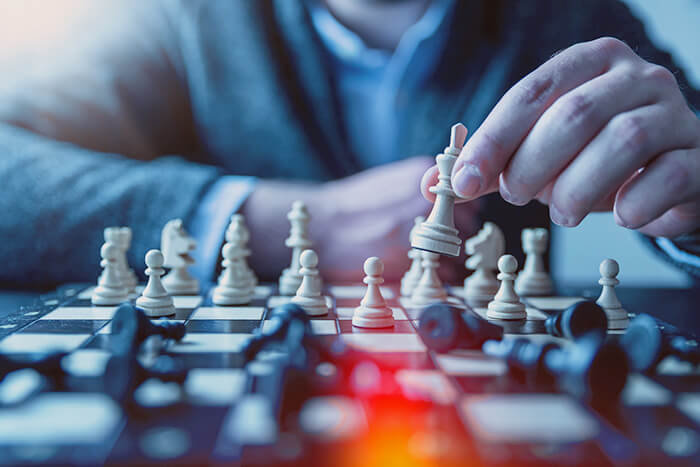 a man playing chess with lights on